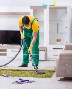 Professional carpet cleaner cleaning a green area rug